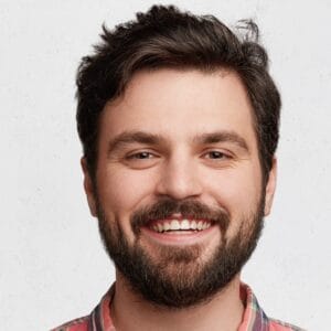 Smiling bearded young male model rejoices coming weekends, dressed casually, isolated over white background. Positive pleased student being in good mood after successfully passed exams at college